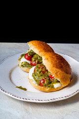 Italian Caprese sandwiches with fresh cherry  tomatoes, mozzarella cheese and pesto sauce.