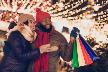 Portrait of attractive cheerful couple buying things mall store festal fair eve time having fun city urban outdoors