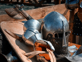 Closeup of a knight's helmet, gloves, shield and battle axe.