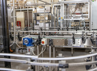 Industrial bottling machine at modern wine factory. Automatic conveyor line for wine-producing