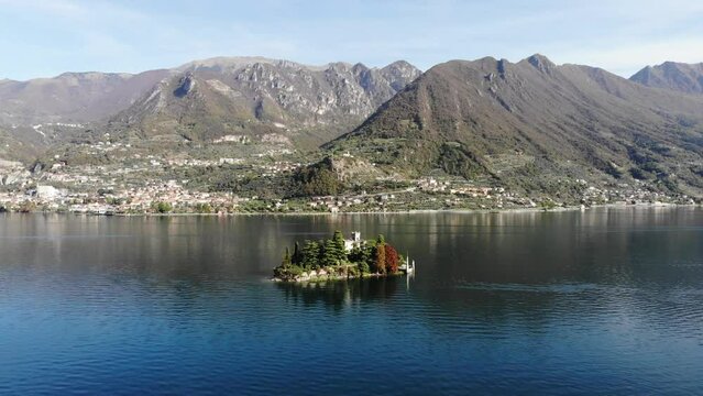 drone slowly rotate around San Paolo island on Iseo lake during a sunny autumn day