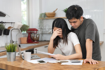 Fototapeta premium Stressed Asian couple reading notice mail from the bank about unpaid house mortgage