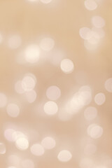 Abstract bokeh background beige colored, natural flare from lights, beige monochromatic vertical photo with optical effect, blurred bokeh texture as holiday backdrop, celebration screensaver