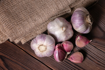 Garlic bulb on wooden background and sackcloth. Close up