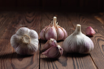 Garlic cloves on wooden table. Fresh peeled garlics and bulbs.