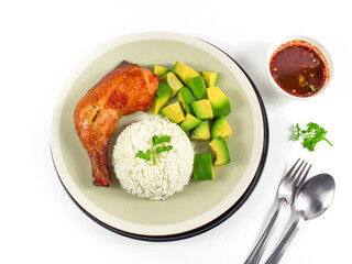 Grilled chicken on white plate with avocado and rice.