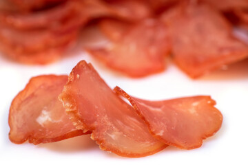 Pieces of beef jerky isolated on white background, top view. Cured meat. Dried meat.