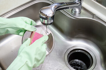 シンクの排水溝を掃除する主婦