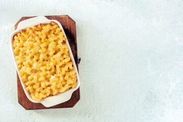 Macaroni and cheese pasta in a casserole, shot from the top. Cheesy American comfort food, baked in the oven, with copy space