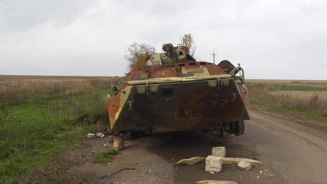 War in Ukraine. Destroyed, burned-out combat vehicle stands on the side of the road