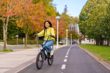 Young asian female student cycling on her way to university in europe, healthy life, eco friendly