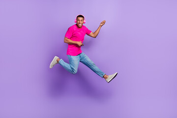 Fototapeta na wymiar Full length portrait of energetic carefree person jumping hands playing imagine guitar isolated on purple color background