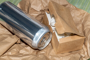 an aluminum beverage can and a cardboard snack box on the background of a craft package