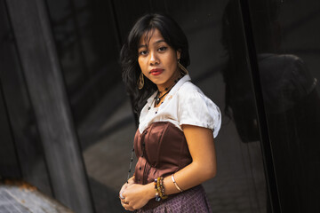 An Asian girl in a vintage Asian traditional long dress, posing for fashion on a black background