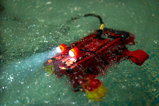 Programmable red aquarobot for children's robotics classes in the pool . Copy space . Children Robotics constructor assemble robot.