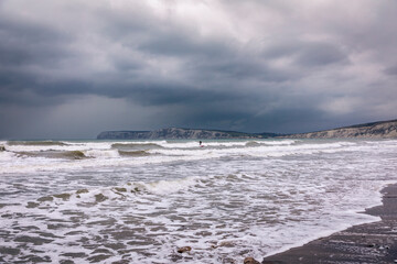 Surfing in the stormy waters at high tide at Compton Bay Isle of Wight south east England