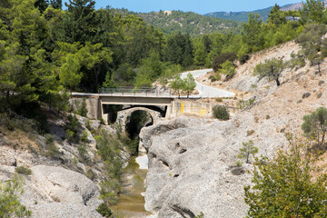 Fototapeta na wymiar Panoramic views of the Blue Mountain River and Stone Bridge. Near the Gadouras Dam. In the south of the island of Rhodes. Dodecanese Greece.