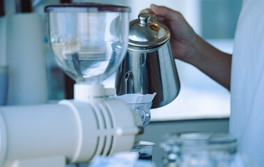 キッチンカーでコーヒーをドリップする女性店員