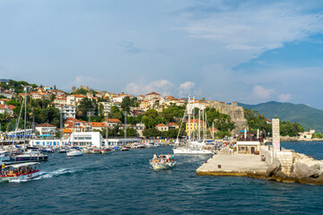 Fototapeta na wymiar View of city Herceg Novi and fortress from pier. Coastal town in Montenegro located at entrance to Bay of Kotor and at foot of Mount Orjen