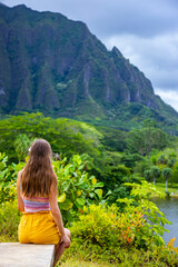 beautiful girl walks through Ho'omaluhia Botanical Garden admiring the mighty mountains on oahu, hawaiian islands; holiday in hawaii