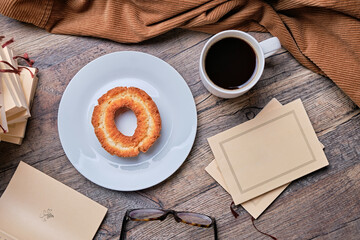 Donuts and paperback on wooden table.