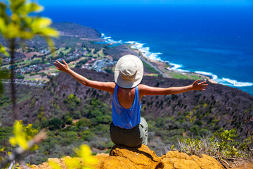girl in a hat enjoys the oahu panorama from the top of the famous koko crater railway trailhead, oahu, hawaii, hiking in hawaii, holiday in hawaii