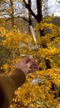 holding a glass in autumn forest