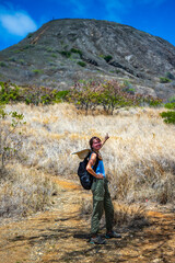 Naklejka premium backapcker girl stands at the foot of the famous koko crater railway trailhead, oahu, hawaii, hiking in hawaii, romantic holiday in hawaii