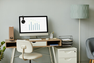 Background image of minimal workplace interior in white tones with PC computer on desk, copy space