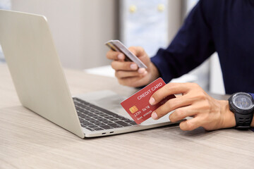 Fototapeta premium Businessman holding credit card for online shopping bill on smartphone, positive man shopping online remote payment , smart payment concept individual bank