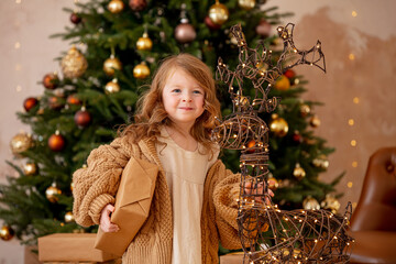 Cute, beautiful child girl at Christmas on the background of a decorated Christmas tree.