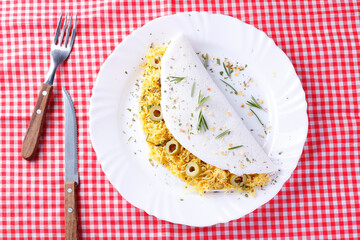 homemade tapioca or beiju stuffed with boiled chicken and olives on rustic wooden table