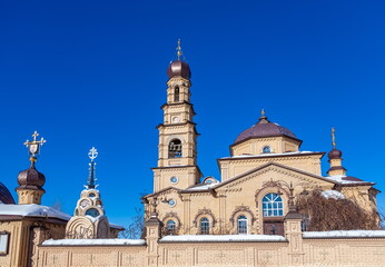 The building of the Orthodox church on the background of blue sky with white clouds in winter. Russia. Ural. Kurganovo