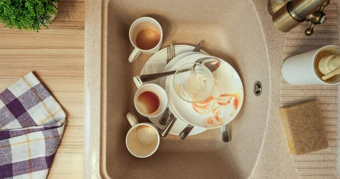 Dirty dishes appear in the sink in the kitchen. 4K stop motion animation
