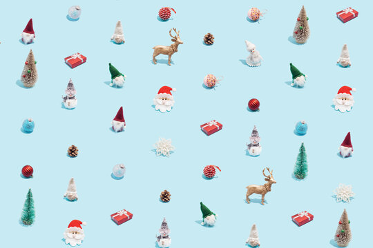 Trendy Christmas pattern made with various winter and New Year objects on bright light blue background. Minimal Christmas concept.