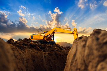 Crawler excavator  are digging  soil in the construction site on the blue sky and sunset  backgrounds