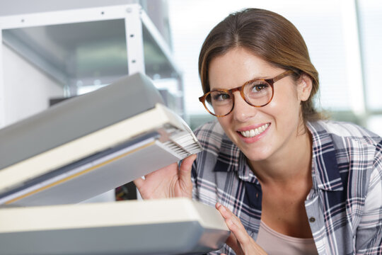 smiling woman lifting the lid of a photocopier