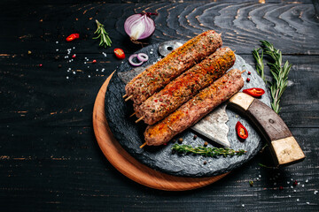 raw Lula kebab on skewers with spices dark background. Lula kebab, traditional Caucasian dish. top view