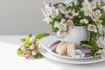 Fototapeta na wymiar Beautiful composition with delicious French macarons and spring flowers in a white cup