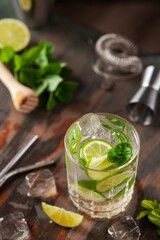 Mojito cocktail with lime and mint in glass on a grey background
