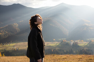 freedom, a young woman stands on top of a mountain