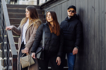 Fototapeta na wymiar Three young models are walking around the city