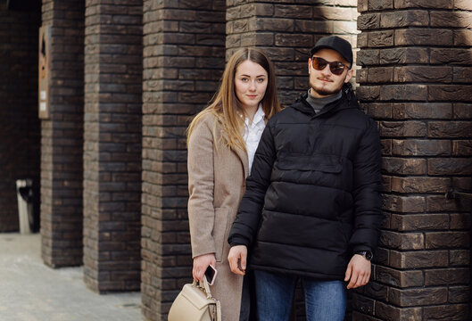 Young couple posing near wall