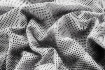 Synthetic fabric with holes laid in waves. Beautiful drape. Fabric for curtains, interior design, and decor. Wrinkled gray fabric.