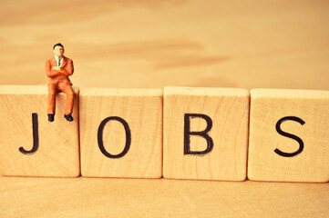 miniature figurine representing unemployed person searching for a job