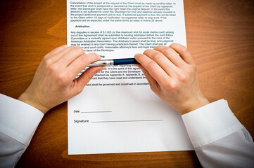 woman's hand holding a pen, ready to sign a contract