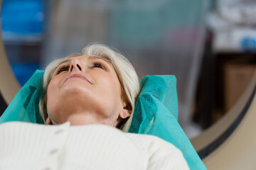 mature woman lying during examination on computed tomography machine.