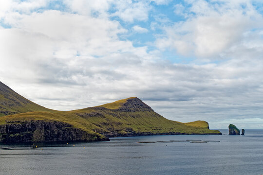 Salmon aquaculture pins near the Drangarnir landmark, Faroe Islands. Aquaculture may conflict with tourism.