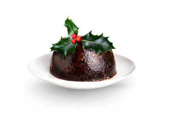 A traditional festive fruit Christmas steamed pudding with holly on the top isolated against a...