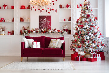 Interior of bright modern living room with fireplace, chandelier and comfortable sofa decorated with Christmas tree and red gifts - 545969917